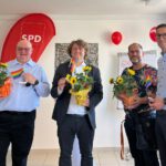 Bernd Lange und Erik von Malottki halten ihre neuen Regenbogenflaggen in der Hand. Neben ihnen stehen Conni Kay und Marcel Spittel.
