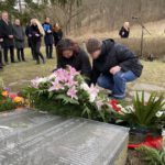 Bianca und Iris legen Blumen am Frauenehrenmal nieder.