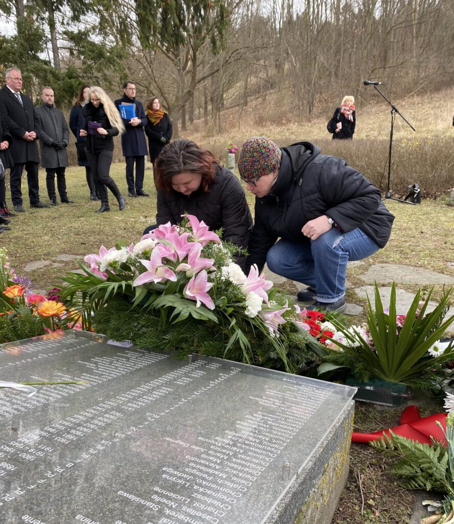 Bianca und Iris legen Blumen am Frauenehrenmal nieder.