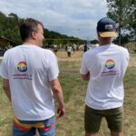 Zwei Personen stehen am Rand eines Volleyballfeldes.